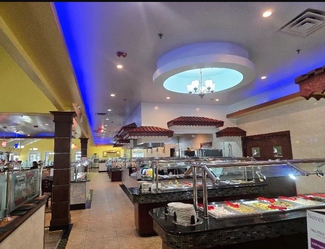 Dining room with buffet counters under a domed ceiling and blue-lit cove
