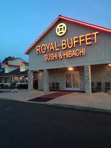 Royal Buffet Sushi & Hibachi storefront at dusk with the lit sign